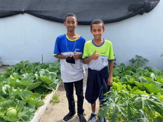 Aluno Odilon ao lado de seu amigo Andrew, também do 4º ano, participam do projeto da horta agroecológica.